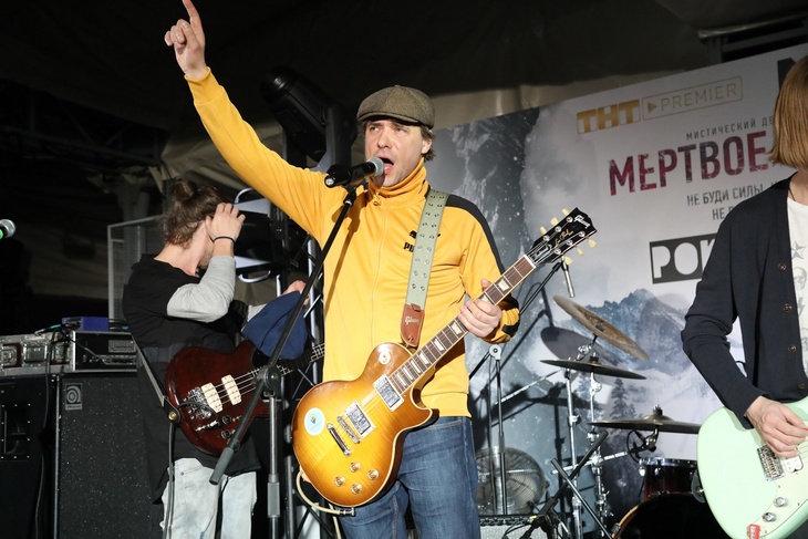 Евгений Цыганов на сцене с гитарой