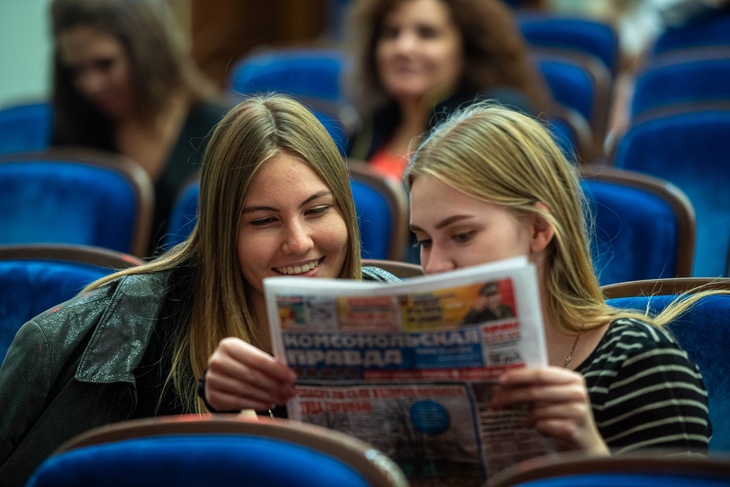 Девушки читают газету