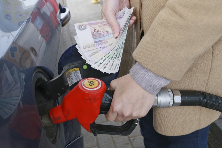 Человек расплачивается за бензин на АЗС