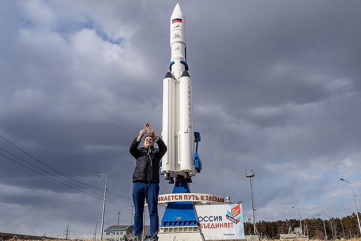 Человек фотографируется на фоне ракеты