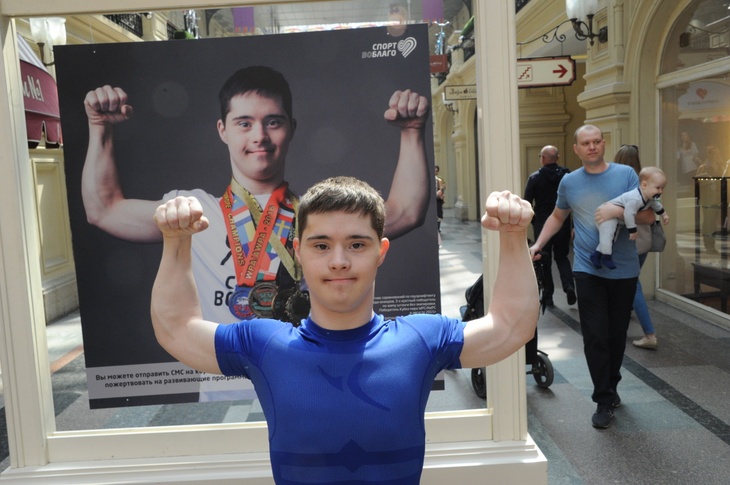 Влад Ситдиков рядом со своим фотопортретом на выставке «Спорт во благо. Дети»