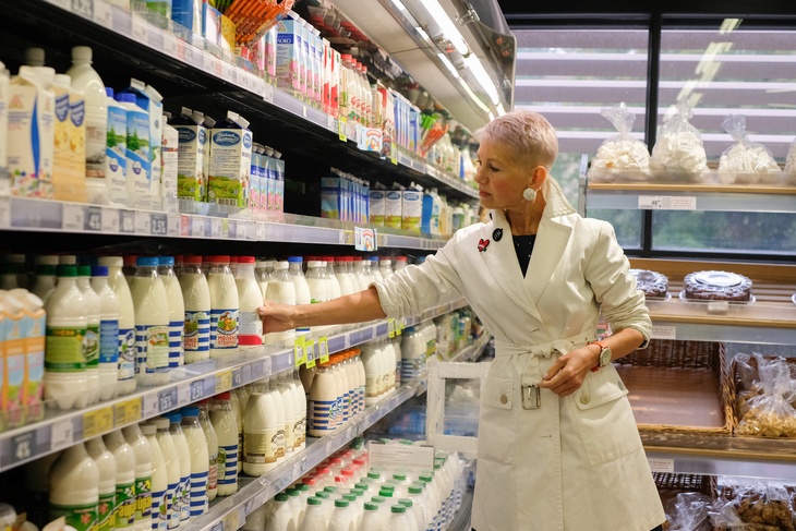 Санкт-Петербург. Женщина делает покупки в молочном отделе магазина. 