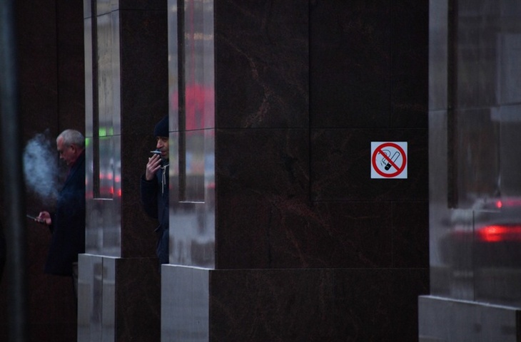 курильщики у знака "курить запрещено"