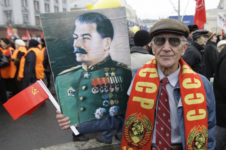 Мужчина держит портрет Сталина