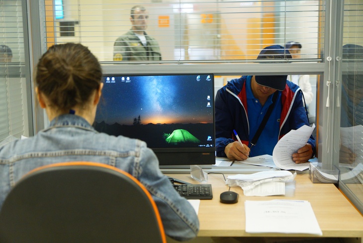 Иностранный гражданин в универсальном миграционном центре во время оформления документов