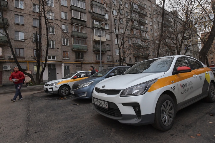 Москва. Автомобили сервиса `Яндекс.Такси` во дворе жилого дома.