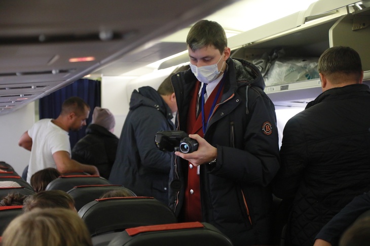 Сотрудник Роспотребнадзора проверяет тепловизором пассажиров прибывшего самолета в связи с эпидемией коронавируса. 