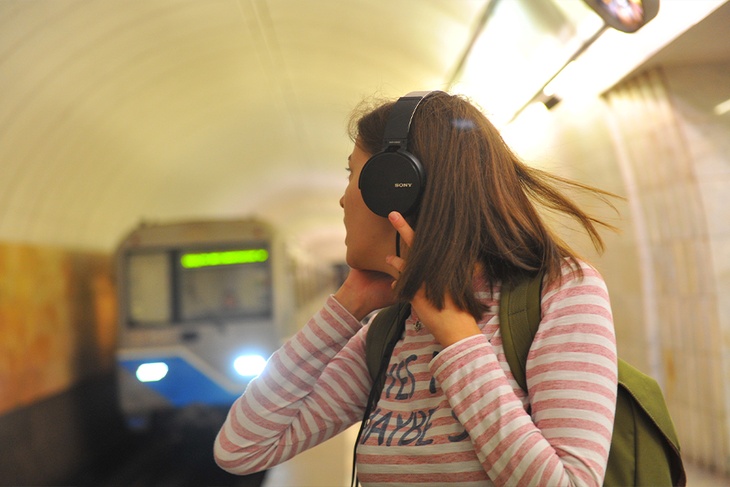 Девушка в наушниках в метро