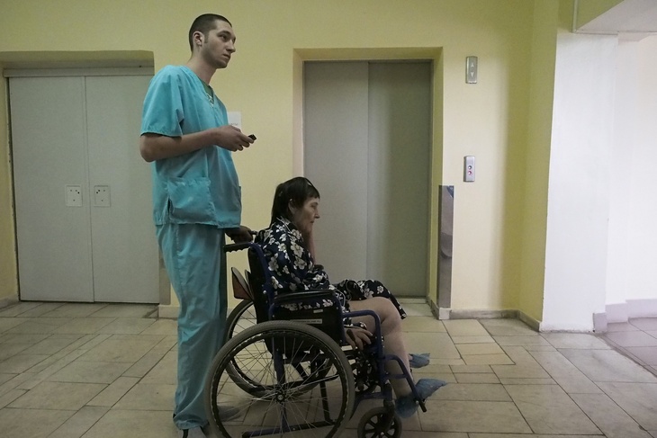 Санитар с пациенткой в больнице
