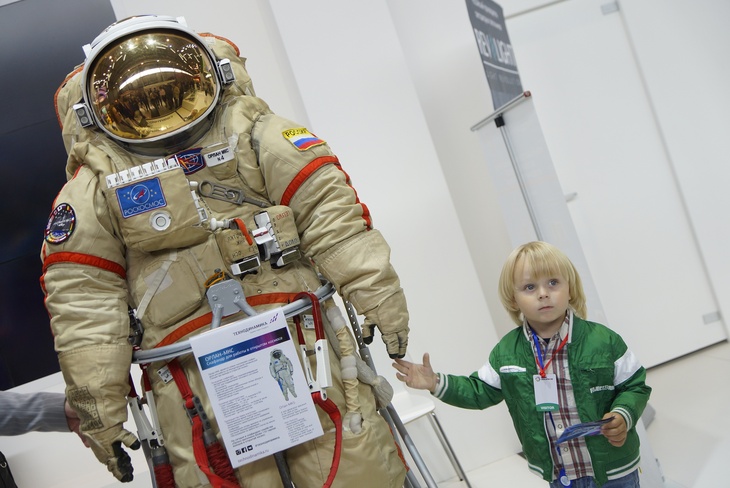 Девочка фотографируется со скафандром космонавта