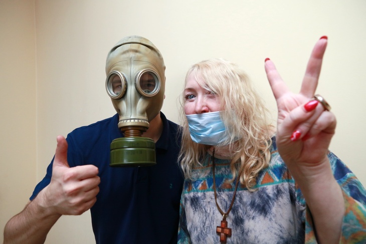 Мужчина в противогазе и женщина в медицинской маске Мужчина в противогазе и женщина в медицинской маске