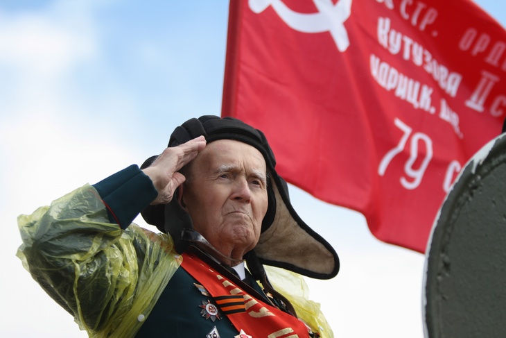 Ветеран на фоне знамени Победы