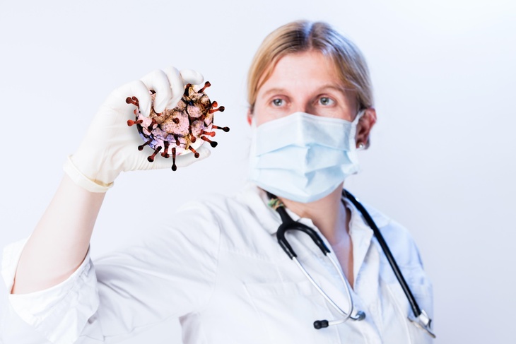 Медик держит в руке вирус