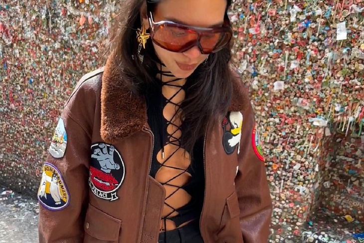 Dua Lipa flashes her breasts under a Patched Bomber Jacket